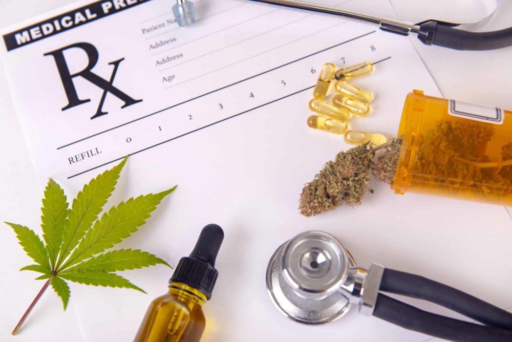 Assorted cannabis products, pills and CBD oil over medical prescription sheet for How to Get a Medical Marijuana Card.